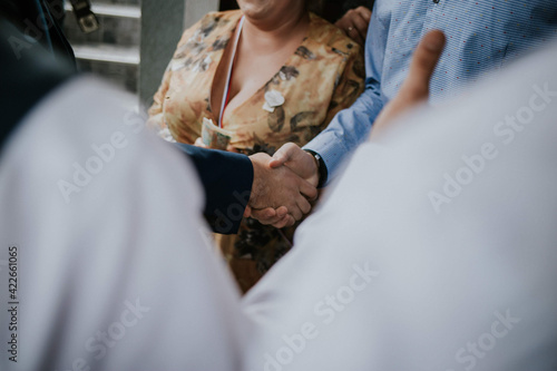 Closeup shot of a  handshake during a wedding ceremony as a sign of a new kinship