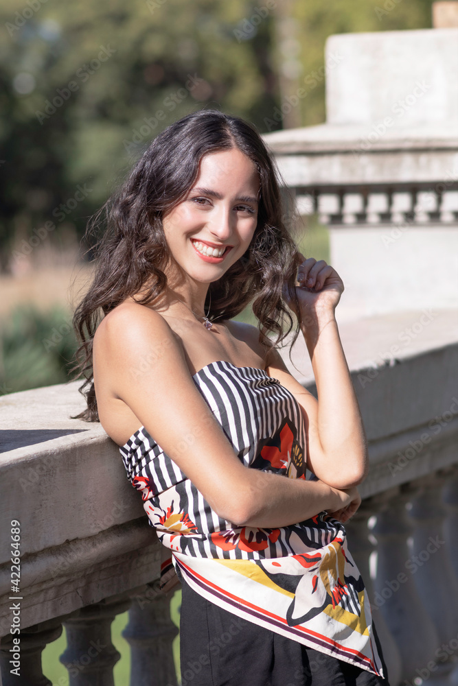 young woman smiling in the park on a sunny summer afternoon