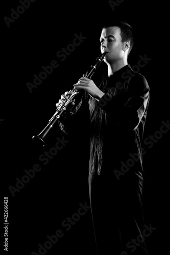Clarinet player classical musician isolated on black. Clarinetist playing music instrument