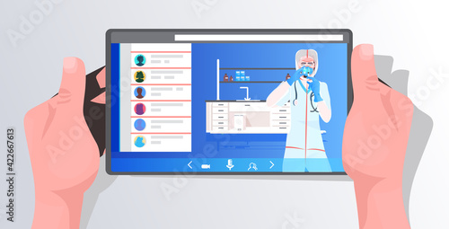 female doctor in mask and protective suit working with test tube on tablet screen vaccine development