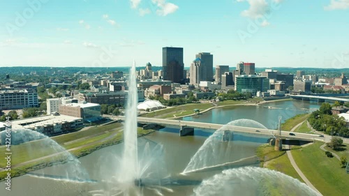 Drone descending over river with river fountain shutting down, downtown Dayton photo