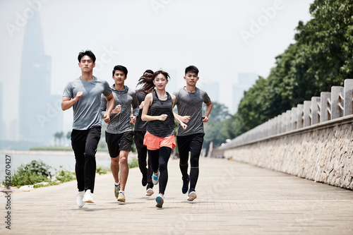 group of young asian adults running outdoors