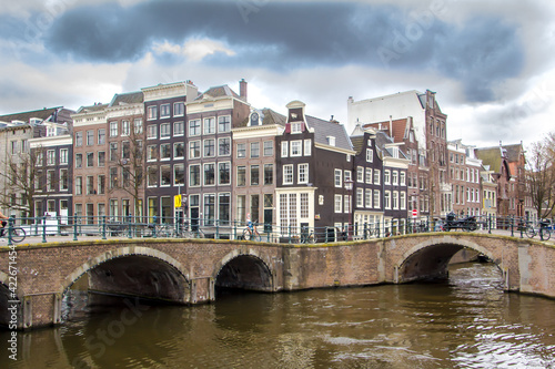 beatiful bridge on the canals of amsterdam with its typical houses