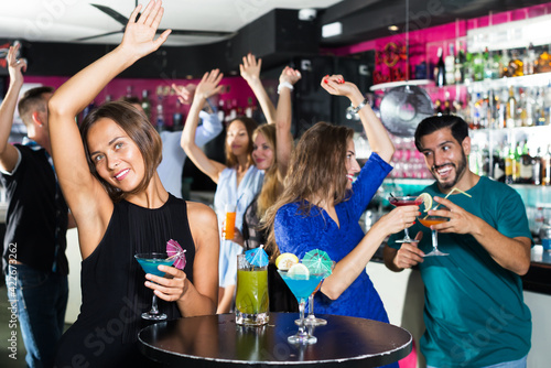 Young cheerful woman is enjoying amazing party in nightclub