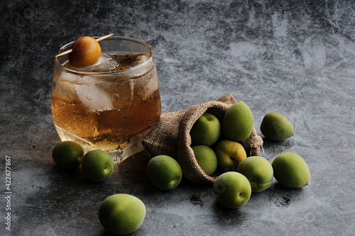 Homemade traditional Japanese green plum wine or UMESHU on Cement floor background.