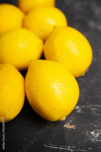 Ripe bright lemons on the dark rustic background. Selective focus. Shallow depth of field.