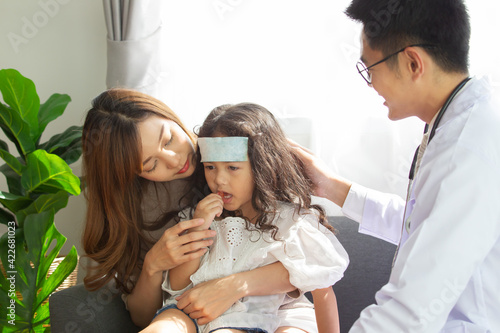 Asian Mother takes her sick young daughter to see a doctor in hospital