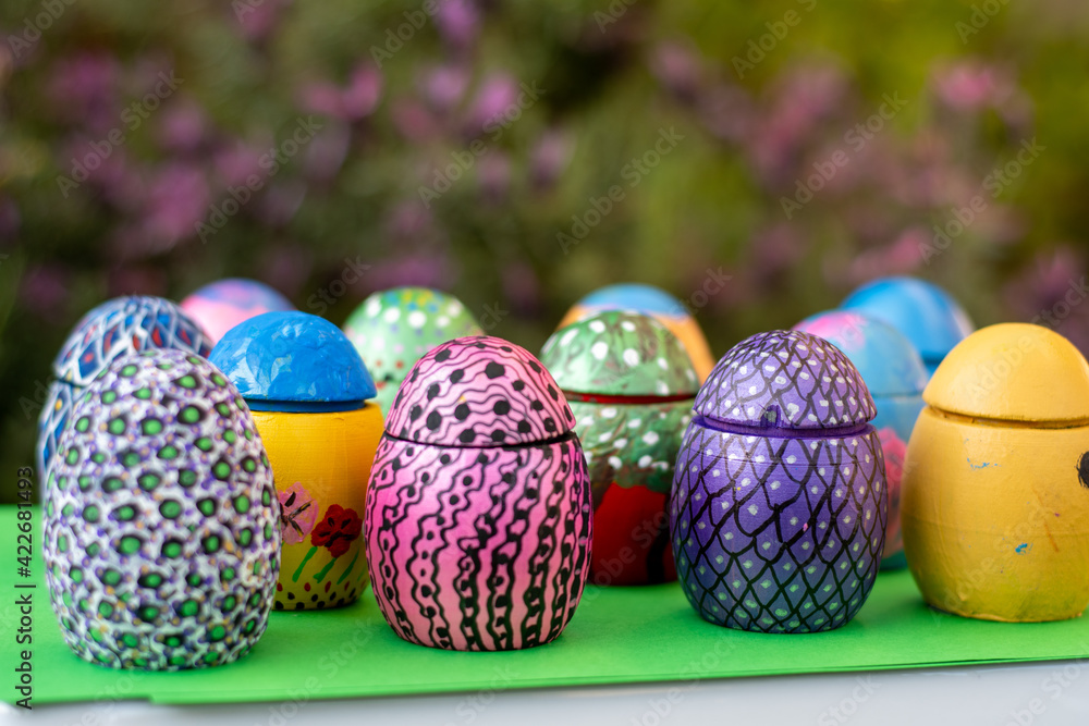 Hand-made Easter eggs on a green pedastal in front of purple lavender flowers. Hand-made Easter eggs on a green pedastal in front of purple lavender flowers.