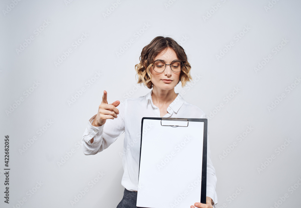 Business woman with a folder of documents in her hands and a white sheet of paper mockup Business woman with a folder of documents in her hands and a white sheet of paper mockup