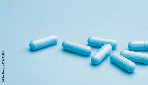 Blue capsule pills on blue background. Online pharmacy banner. Group of capsule pills. Pharmaceutical industry. Drug development and new drug research for treatment emerging Infectious diseases.