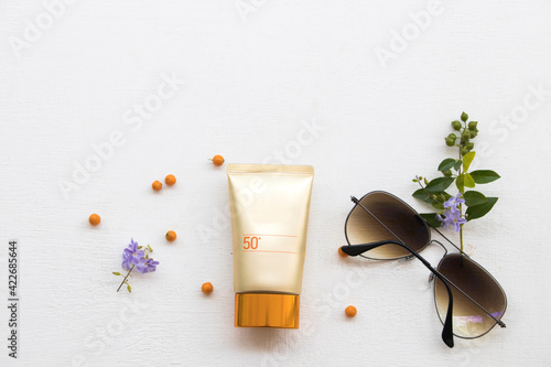 Fototapeta Naklejka Na Ścianę i Meble -  natural cosmetics sunscreen spf50 health care for skin face with flowers of lifestyle woman relax in summer season arrangement flat lay style on background white 