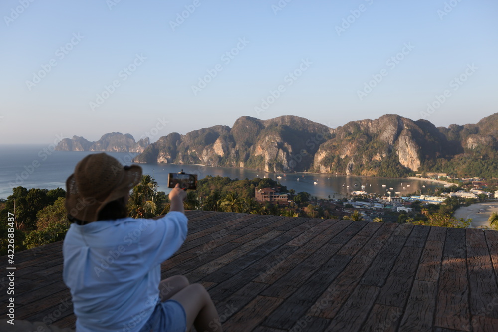 woman wearing a hat is looking at a beautiful natural view.