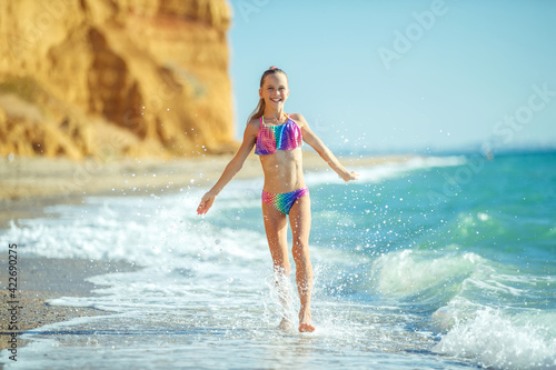 Child girl runs on the waves. Rest by the sea, fun outdoors. High quality photo.