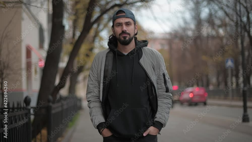 Young attractive man looks at the camera in a city park on a sunny autumn day. Young attractive man looks at the camera in a city park on a sunny autumn day.