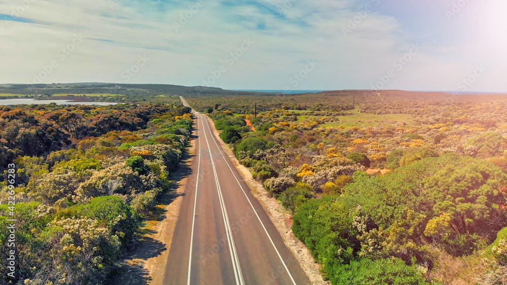 Obraz premium Road across the island, aerial view from drone on a beautiful sunny day. Holiday and vacation concept