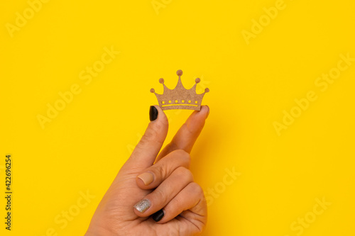 wooden crown in hand over yellow background, concept for king , queen power. photo