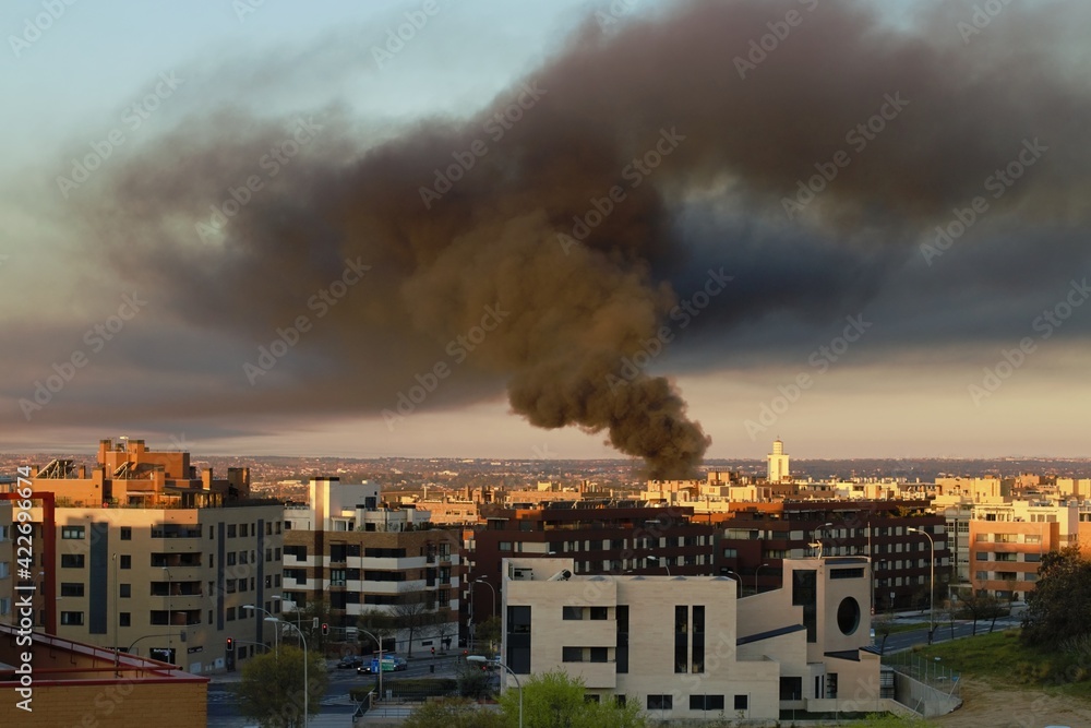 Madrid, España. 03 24 2021. Incendio de una nave industrial en el barrio de Montecarmelo en la calle Monasterio de las Huelgas. Nube de humo negro sobre el cielo de Madrid al amanecer. Madrid, España. 03 24 2021. Incendio de una nave industrial en el barrio de Montecarmelo en la calle Monasterio de las Huelgas. Nube de humo negro sobre el cielo de Madrid al amanecer.