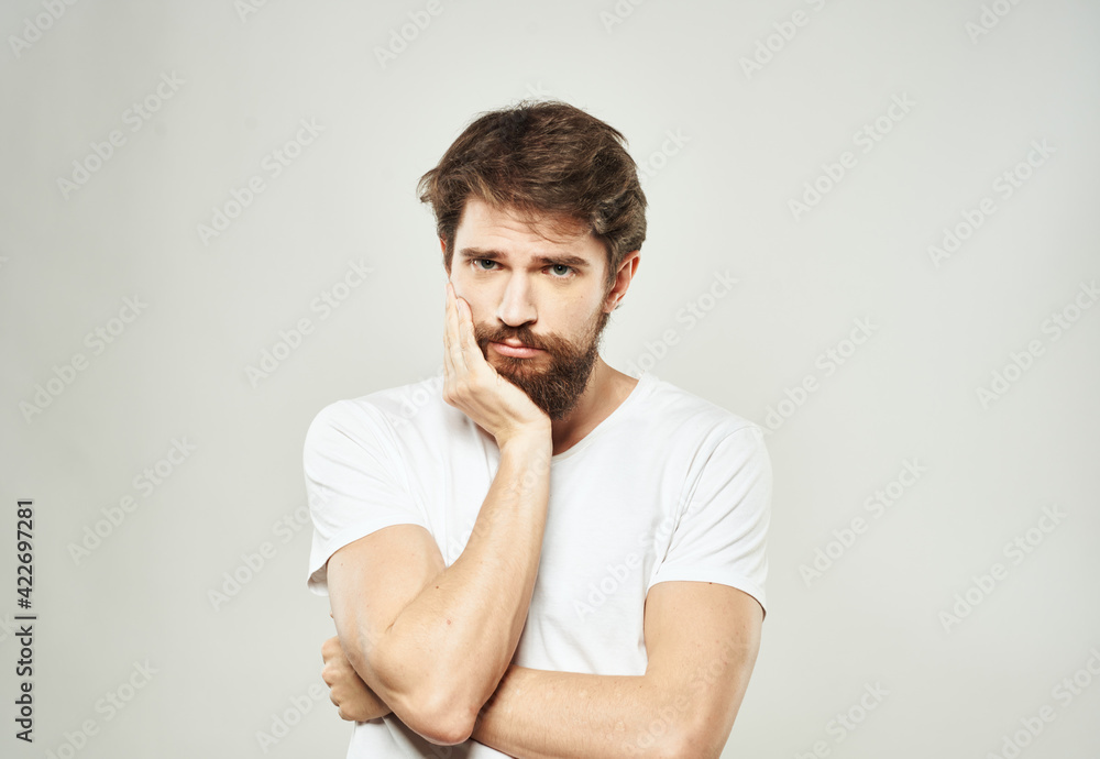 Man touches face with hands emotions model light background Man touches face with hands emotions model light background