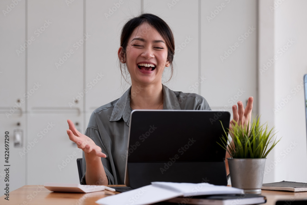 Portrait of an excited young asian girl using laptop computer and celebrating success for online learning or working at home Portrait of an excited young asian girl using laptop computer and celebrating success for online learning or working at home
