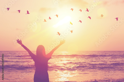 Copy space of woman raise hand up on sunset sky at beach and island background.