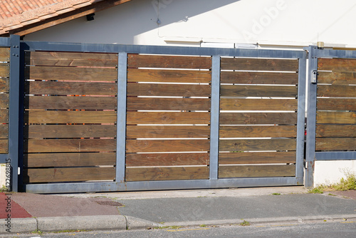 wooden and steel dark natural brown gate portal of suburb door house © OceanProd
