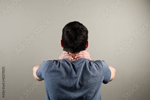 Rear view of man with neck pain. Health problem at office work