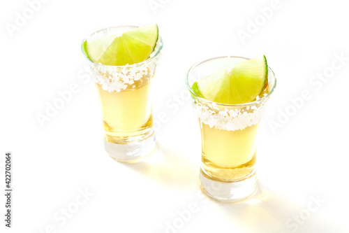 Tequila shots with salt and lime on white