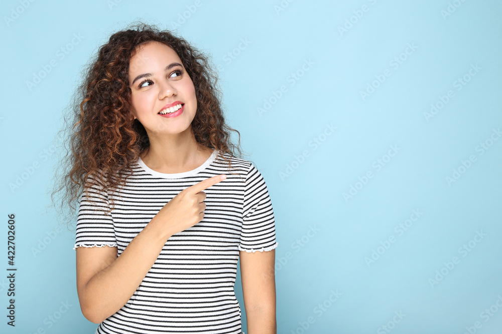 Young american girl pointing by finger on blue background Young american girl pointing by finger on blue background