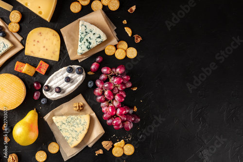Cheese variety, with fruits and snacks, shot from the top