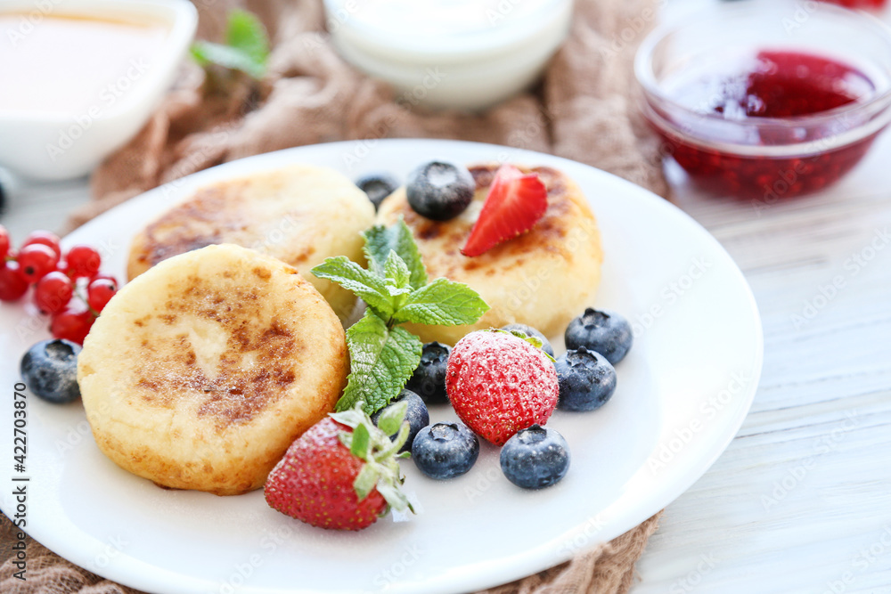 Sweet cheese pancakes with berries and mint leafs on wooden table Sweet cheese pancakes with berries and mint leafs on wooden table