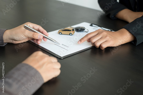 The car dealer provides advice on loans, insurance details, and car rental information, and delivers the car with the keys after the rental contract is signed