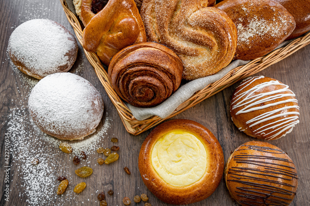 Basket of freshly baked dinner rolls with tableware in wooden background. Macro with shallow dof. Basket of freshly baked dinner rolls with tableware in wooden background. Macro with shallow dof.