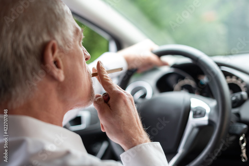 Man smoking a cigarette while driving