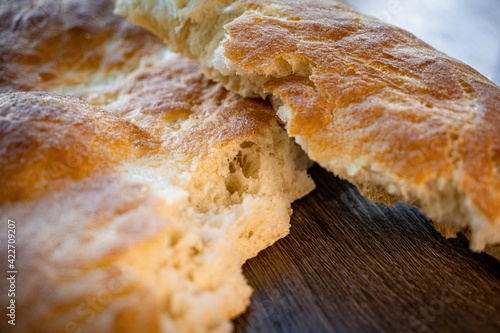 Fresh baked bread and sliced bread on rustic wooden table