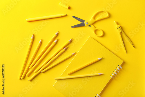 Pencils, scissors and notebook on color background