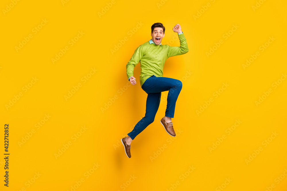 Full length body size profile side view of attractive funky motivated cheerful guy jumping running isolated on bright yellow color background Full length body size profile side view of attractive funky motivated cheerful guy jumping running isolated on bright yellow color background