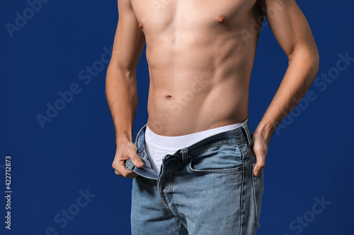 Sexy young man on color bac...