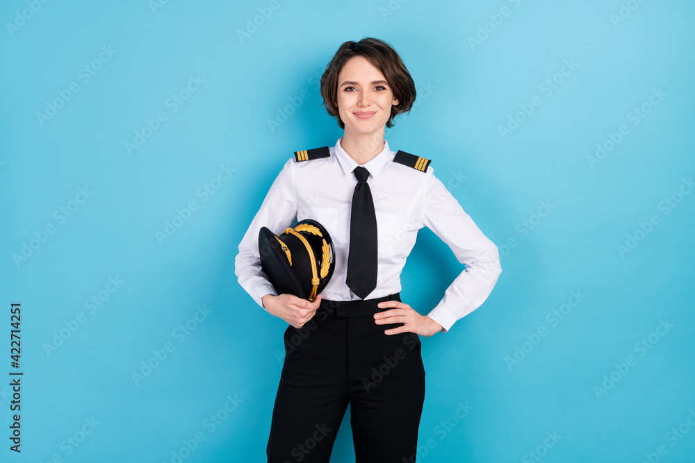 Photo of happy pretty young woman hold hand waist good mood pilot isolated on pastel blue color background - obrazy, fototapety, plakaty 