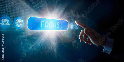 A businessmans hand selecting an Focus business word concept on a computer display.