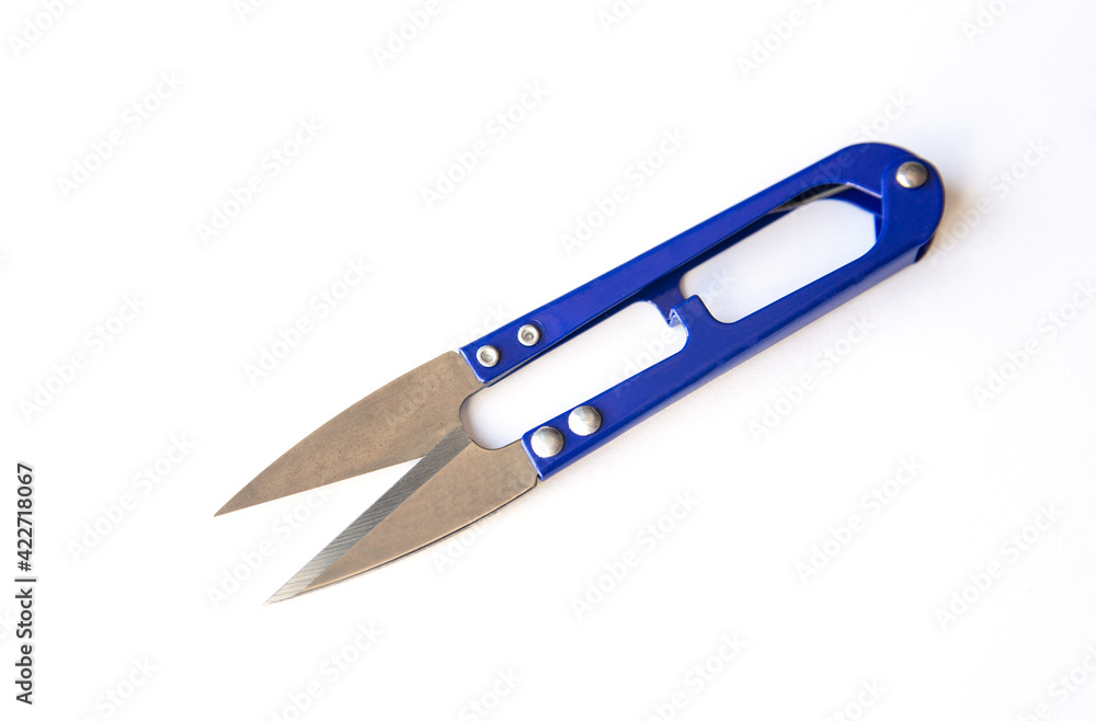 Blue scissors to cut the thread isolated on white background Blue scissors to cut the thread isolated on white background