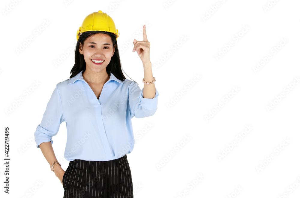 Cute young and beautiful Asian female engineer wearing yellow safety hard hat standing and pose with happy and smile face isolated on white background. She point finger to high blank space Cute young and beautiful Asian female engineer wearing yellow safety hard hat standing and pose with happy and smile face isolated on white background. She point finger to high blank space