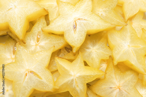 Pile of delicious carambola slices as background, top view