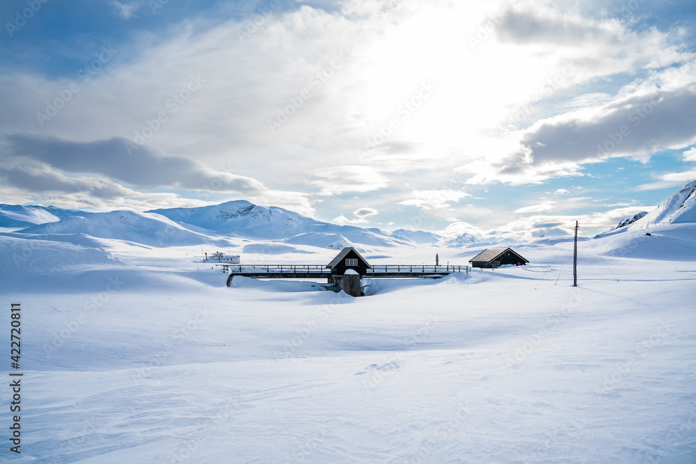 Naklejka premium Hydro electric dam in the mountains covered in snow and ice in the middle of winter.