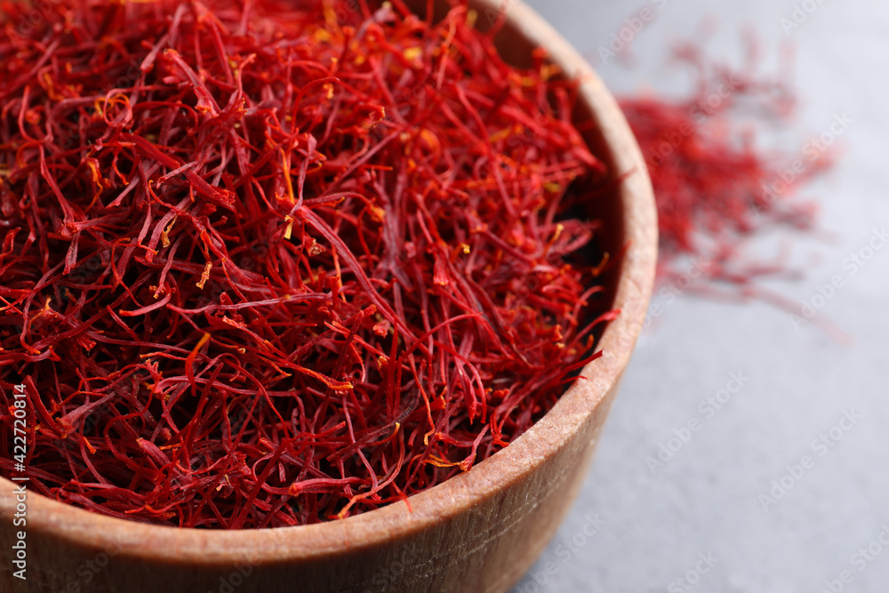Fototapeta premium Dried saffron in bowl on table, closeup