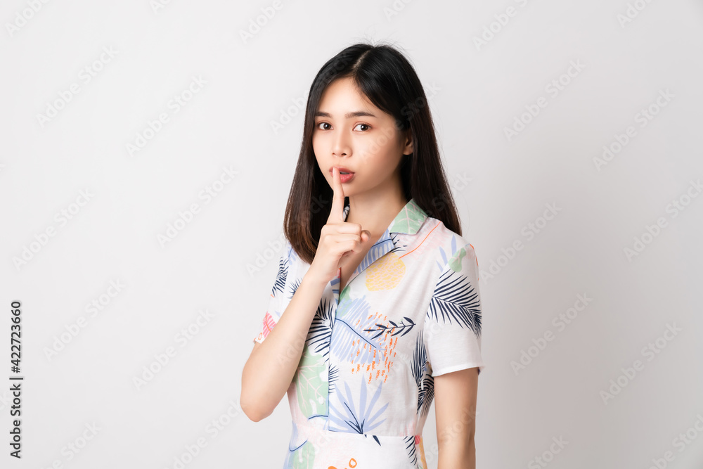 Beautiful Asian woman stand with finger over mouth and shows hush sign, shh or not say a secret. Beautiful Asian woman stand with finger over mouth and shows hush sign, shh or not say a secret.