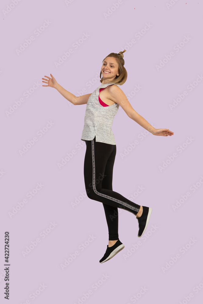 Beautiful woman, young lady, girl is jumping happy sports clothing joyful enjoying yoga