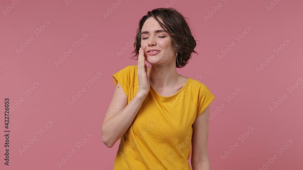 Tired sad short hairdo young woman 20s in basic casual yellow t-shirt did not get enough sleep last night after party and barely got up in the morning yawning isolated on pastel pink background studio Tired sad short hairdo young woman 20s in basic casual yellow t-shirt did not get enough sleep last night after party and barely got up in the morning yawning isolated on pastel pink background studio