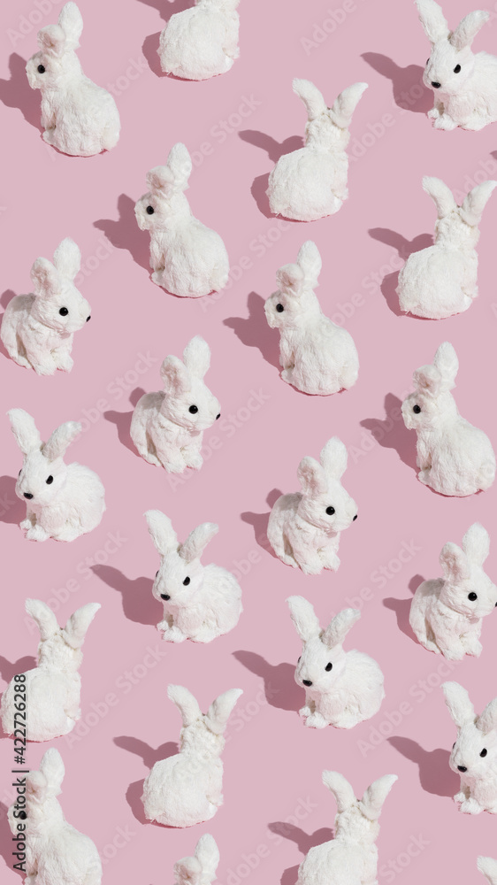 Pattern made with white bunnies on pastel pink background. Minimal Easter concept. Creative abstract layout.