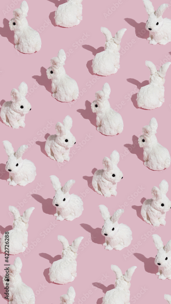Pattern made with white bunnies on pastel pink background. Minimal Easter concept. Creative abstract layout. Pattern made with white bunnies on pastel pink background. Minimal Easter concept. Creative abstract layout.