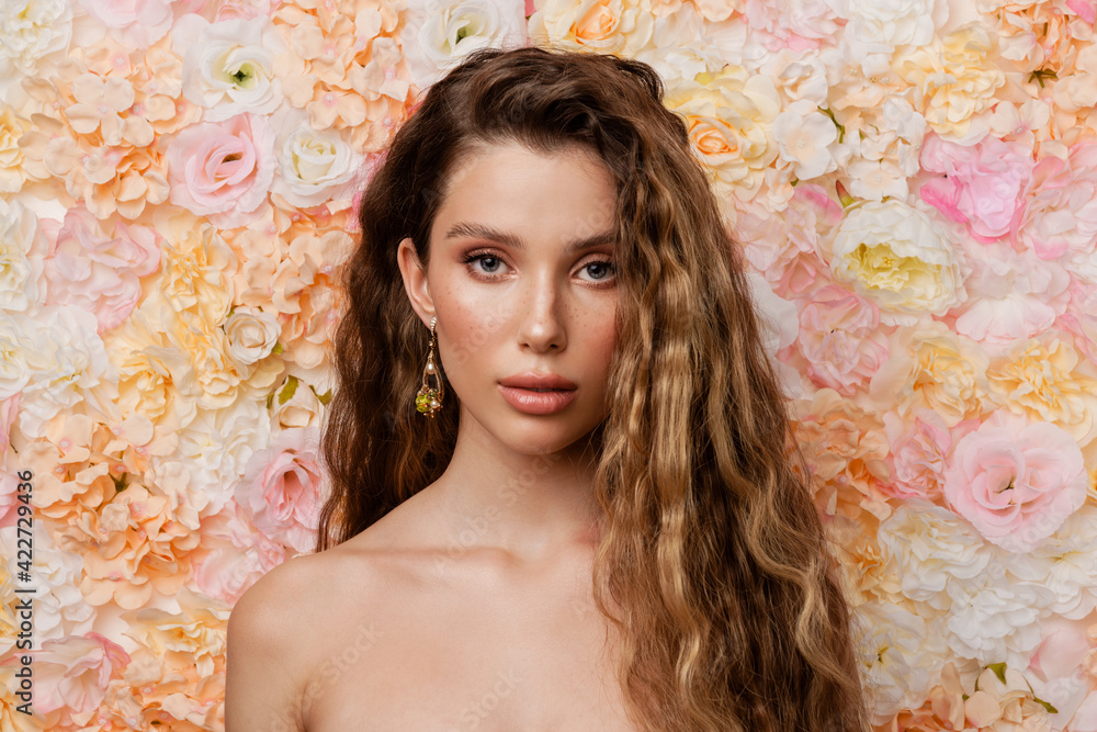 Half-naked woman with earring posing and looking at camera Half-naked woman with earring posing and looking at camera